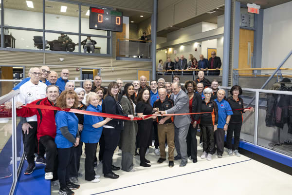 Plusieurs personnes coupant un ruban rouge afin d'inaugurer les nouveaux terrains de bocce