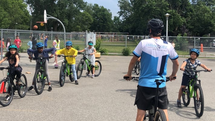 Groupe d'enfants à vélos regardent un instructeur.