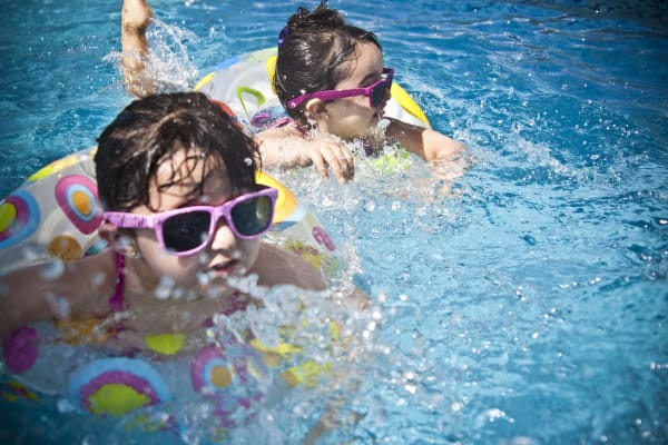 Deux enfants avec flotteurs dans l'eau