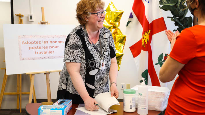 Anne-Renée tient un kiosque d'accueil lors d'un événement interne