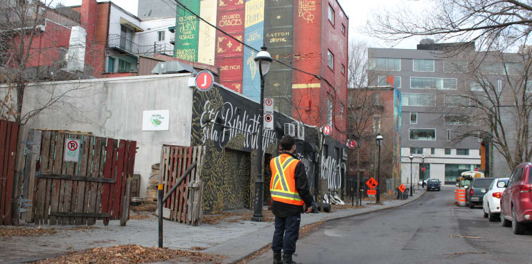 Un homme de dos dans une ruelle avec des graffitis