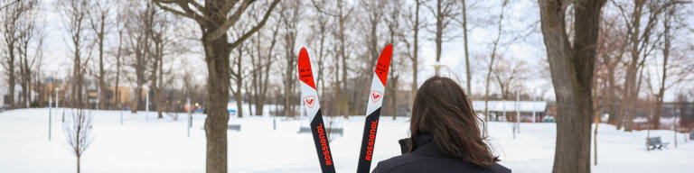 Personne de dos avec des skis au parc Raimbault