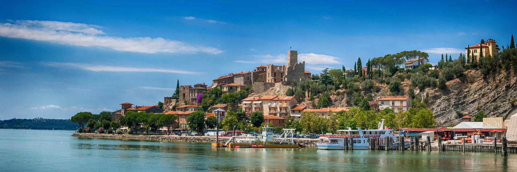 Lago Trasimeno med stille vand og hyggelige huse ved breden, Umbrien