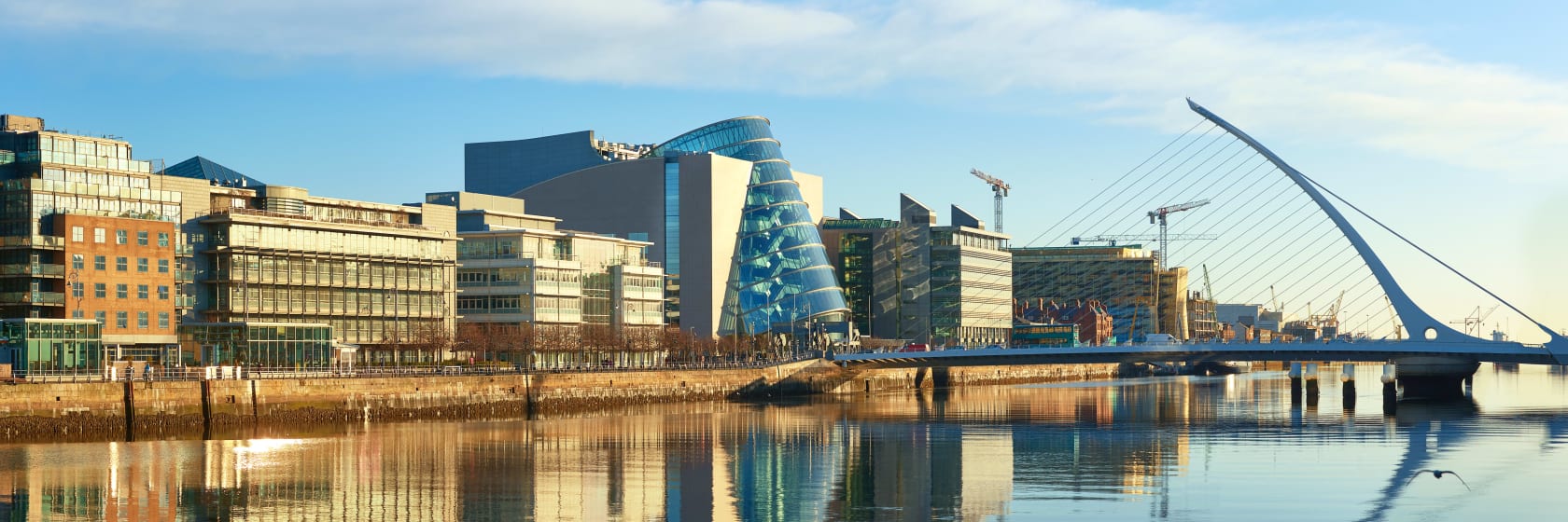 Moderne bygninger p Liffey-floden i Dublin og Harp bridge