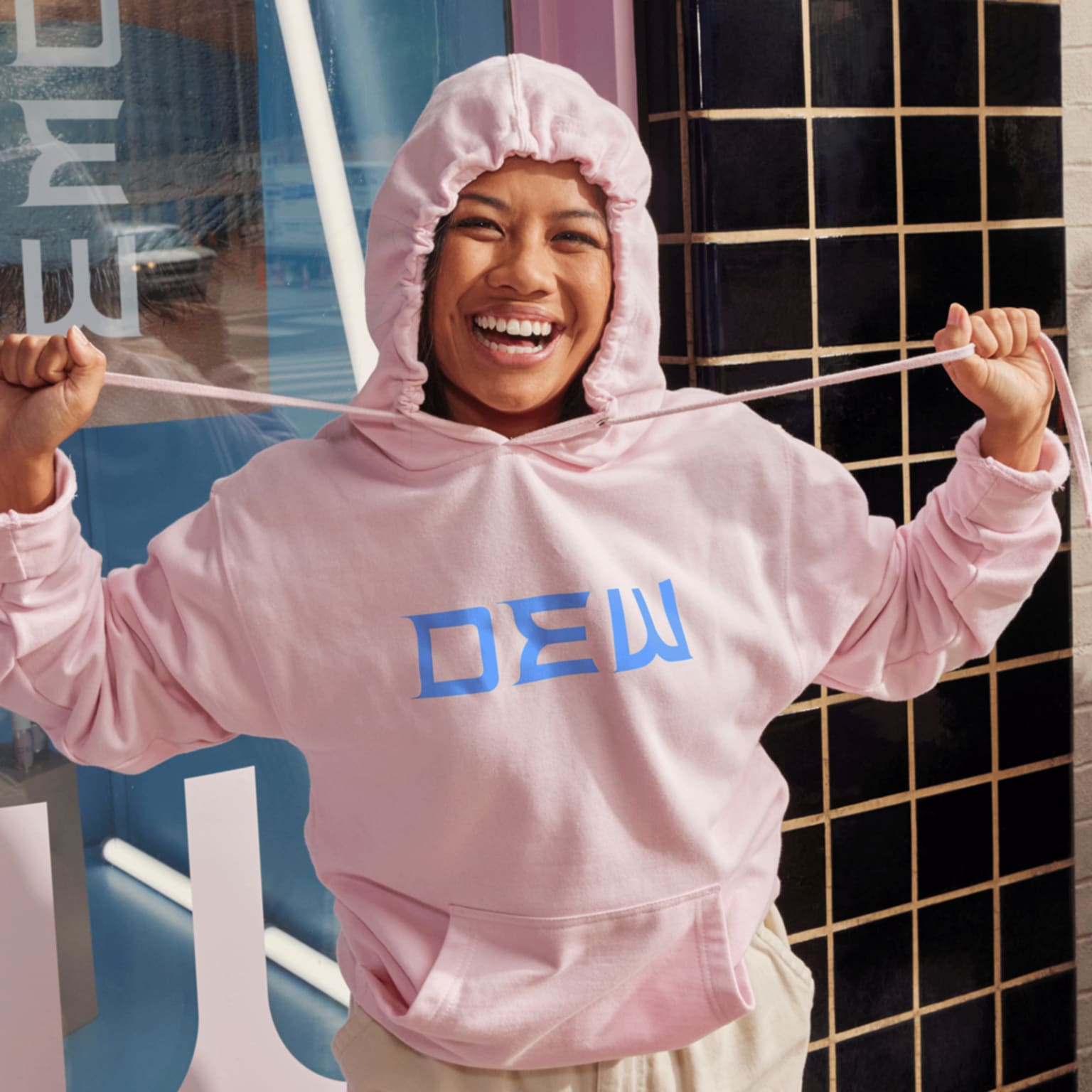 A smiling woman wearing a branded hoodie