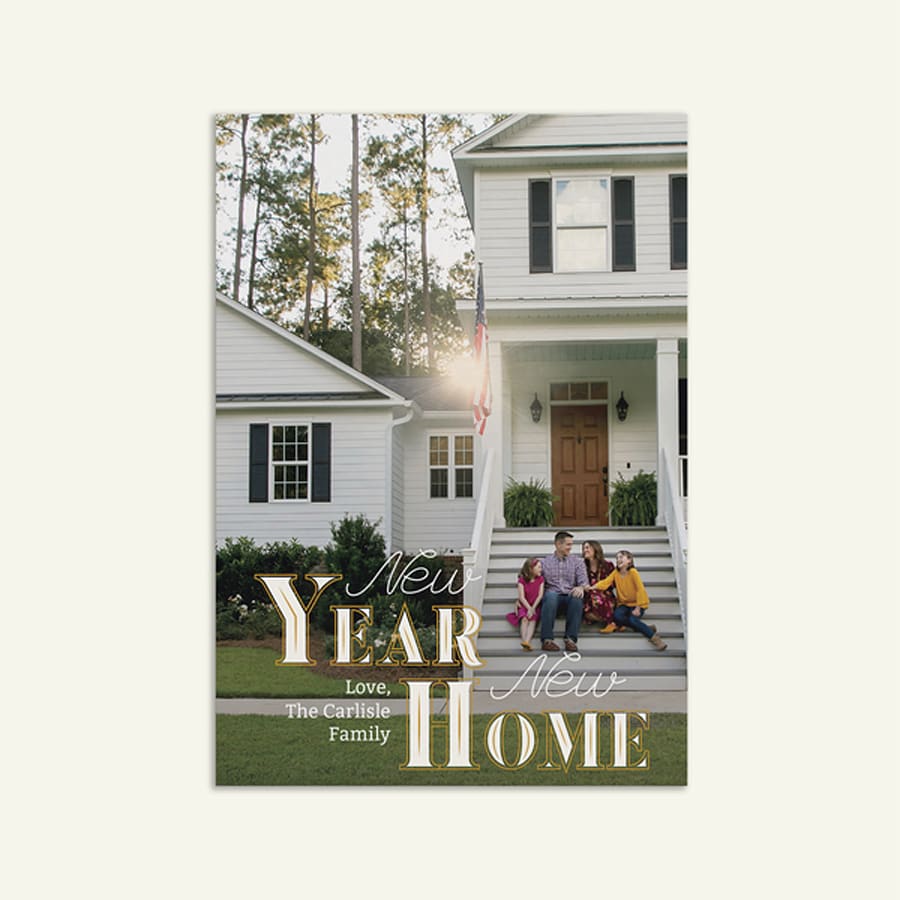 New Year and new home announcement card featuring a family sitting outside their new house.
