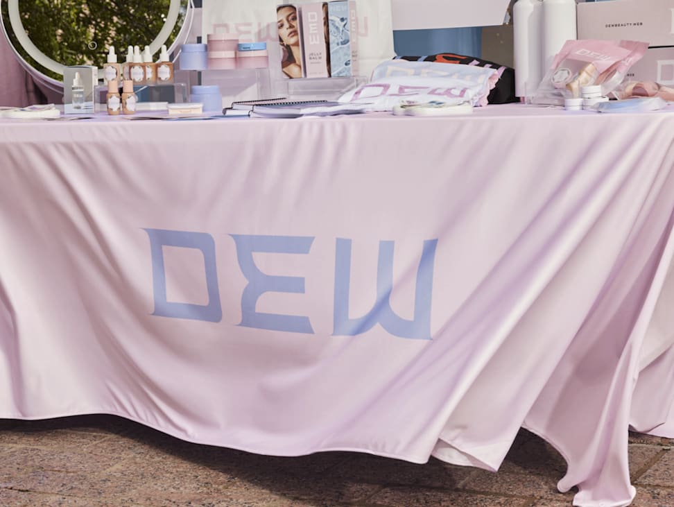 A light pink branded tablecloth with promotional products at an event