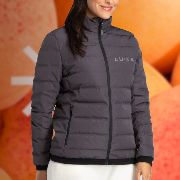 A woman wearing a black padded jacket with a subtle chest logo