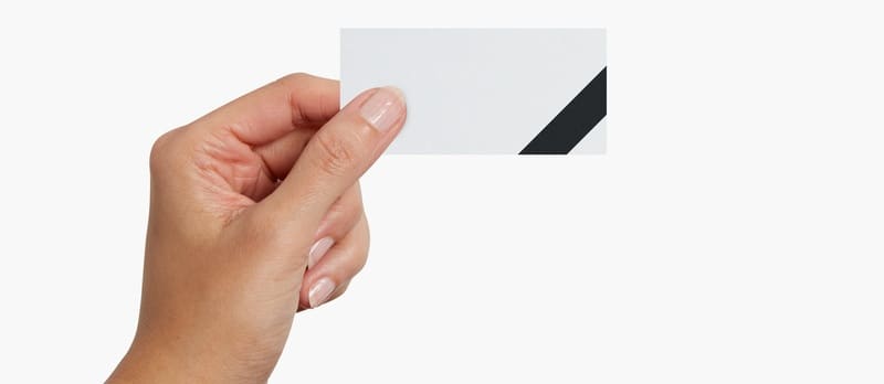 Hand holding a natural uncoated slim business card with a blank black-and-white design.
