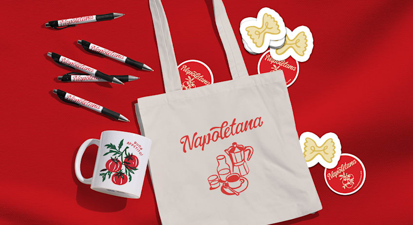 A branded tote bag, stickers, pens and a mug on a red background