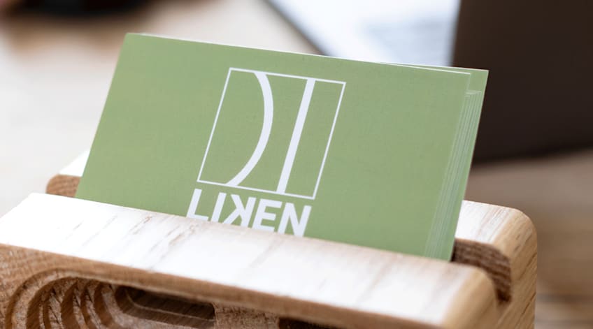 Green matte business cards with company logo Liken printed on the front