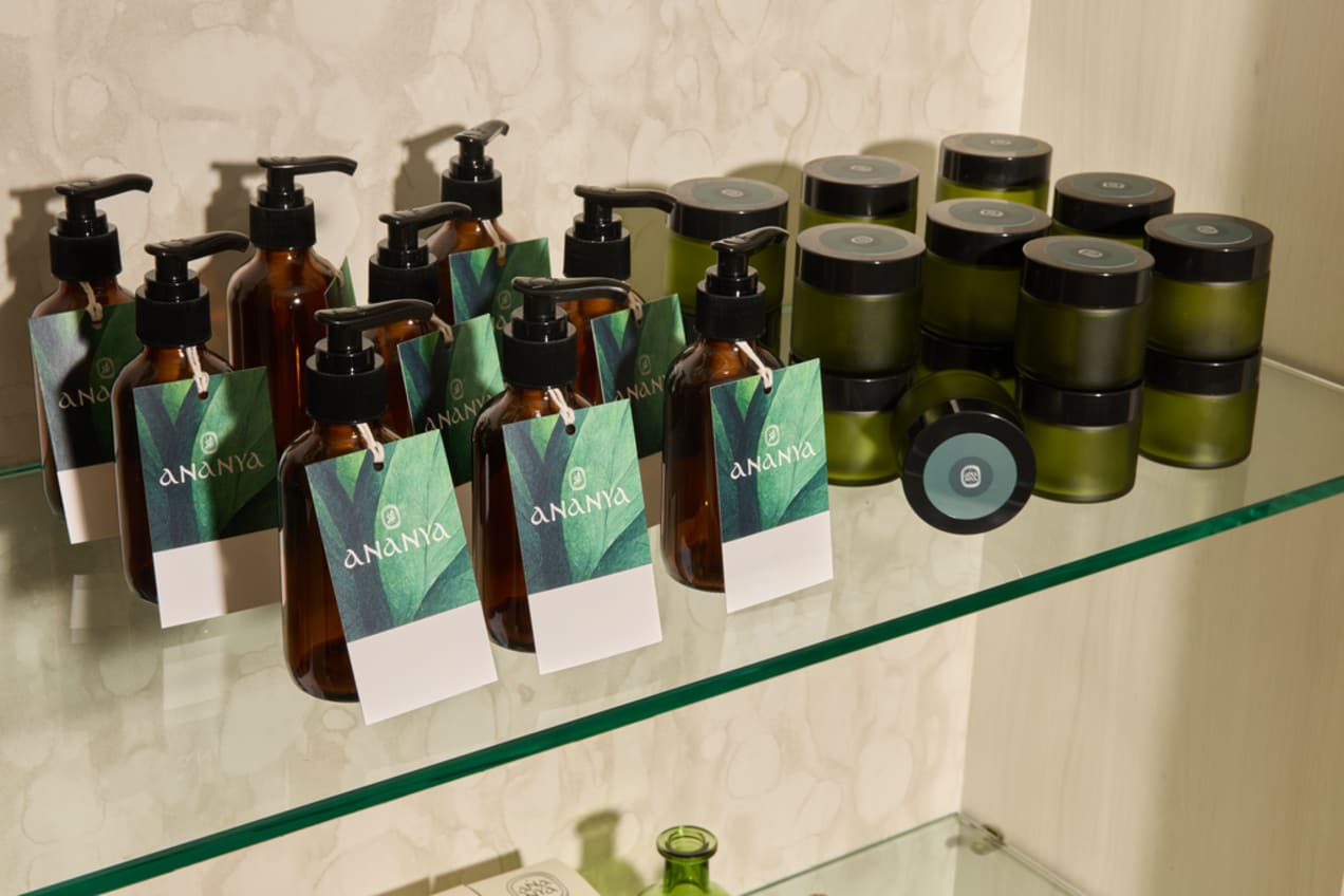 A shelf of bottled beauty products with branded packaging in green tones