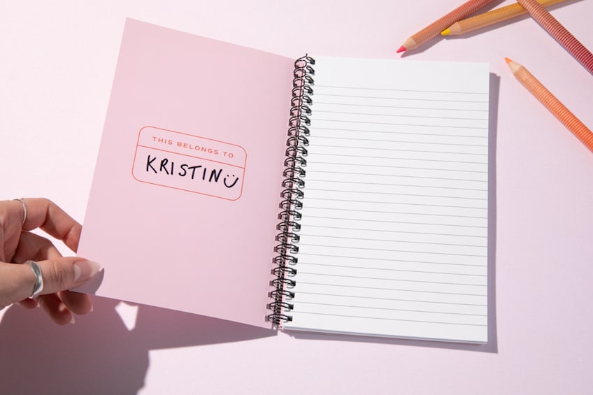 A branded pink notebook as holiday gift ideas for employees