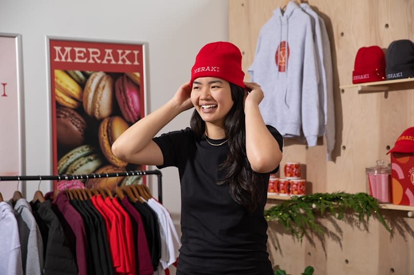 Employee wearing a red branded beanie, holiday gifts