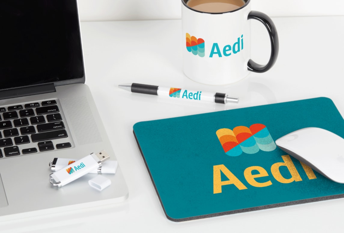 Aedi pen, USB, mousepad and mug merchandise with brand logo and colors