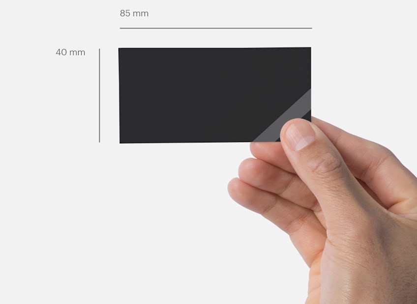 Hand holding a slim business card with dimensions labeled 85 mm wide by 40 mm high.