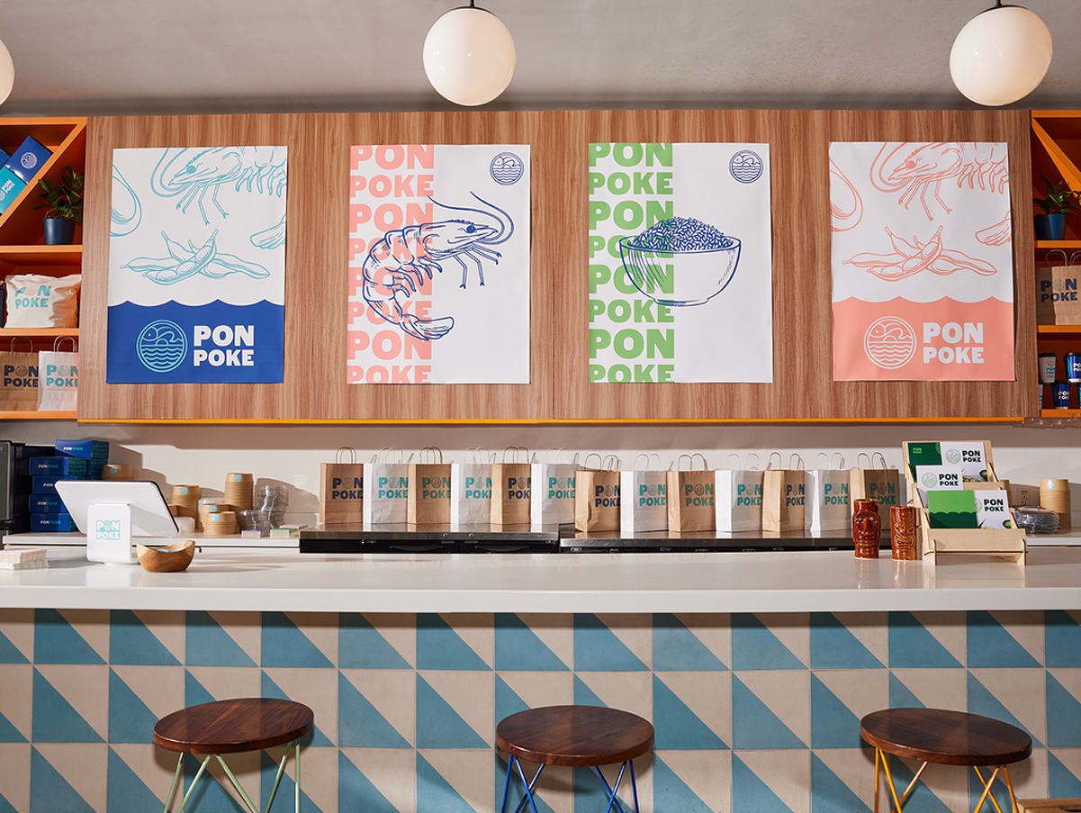 Poke restaurant posters on a wooden wall featuring a range of colors