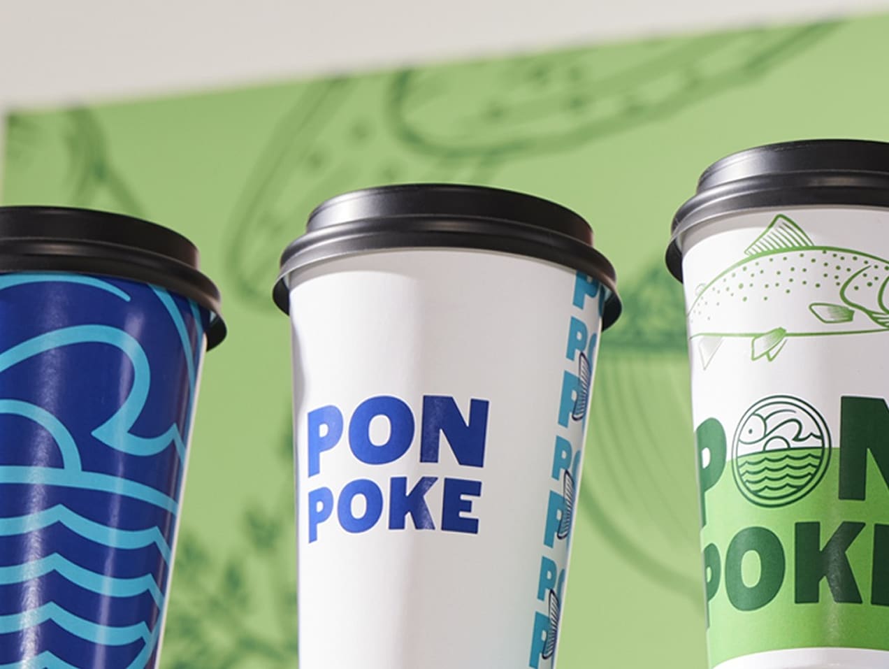 Paper cups with blue and green restaurant branding with fish illustrations and bold logo.