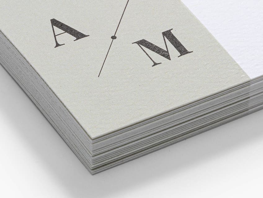 Gray natural textured business card paper with a monogram company logo