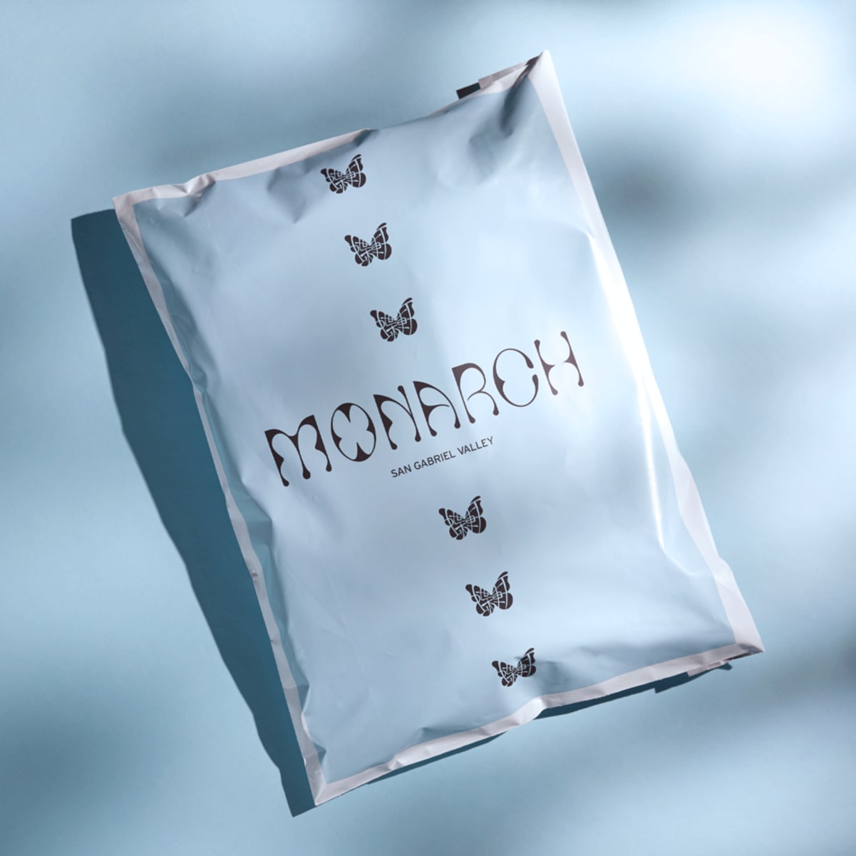 Branded poly mailer with a butterfly logo label design for shipping