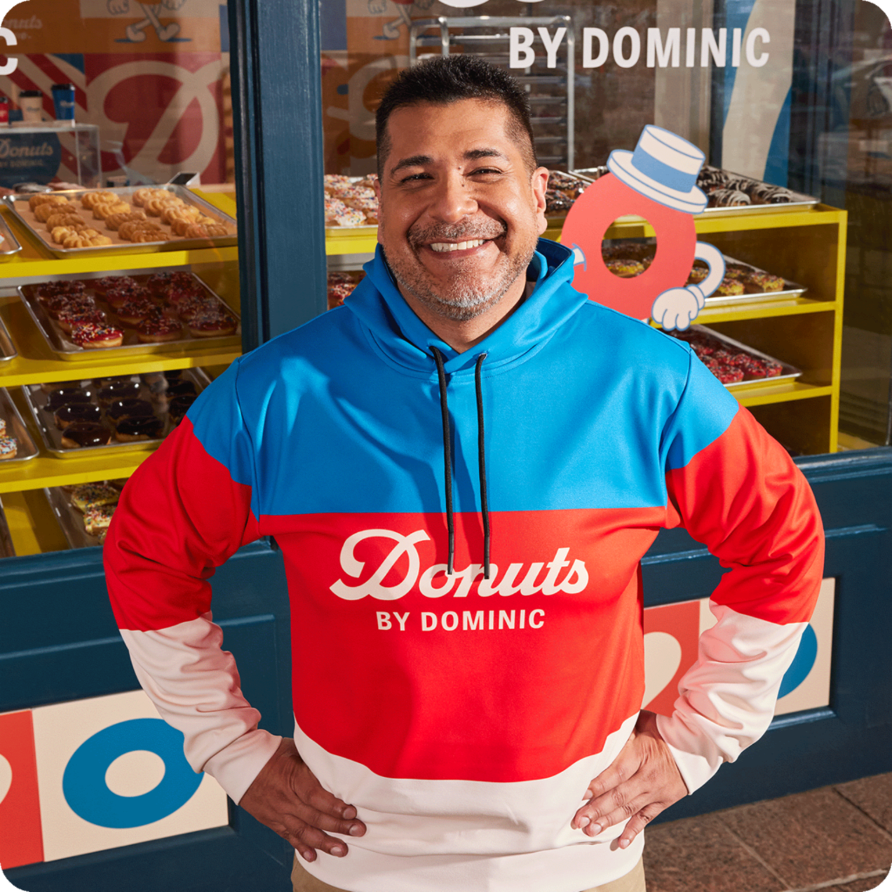 A man wearing a red, blue and white striped hoodie with a donut brand logo printed on the front