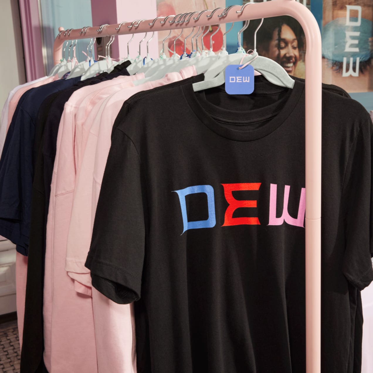 A rail with black and pink T-shirts and hoodies with a brand logo print