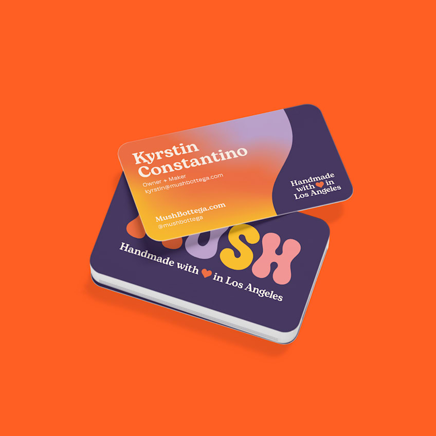 Orange and purple rounded business cards for Mush Bottega with contact details and the phrase “Handmade with love in Los Angeles.”