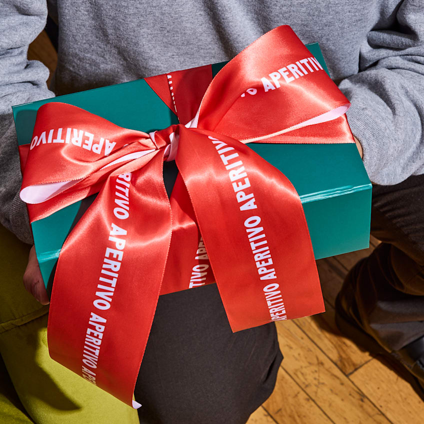 A gift wrapped in green paper with a red ribbon