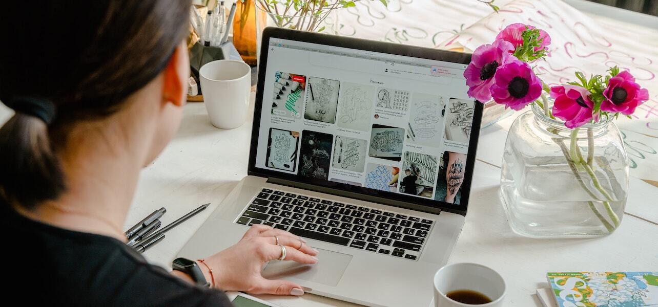 A business owner reviews website designs on a laptop.