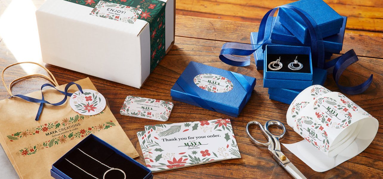 An assortment of branded packaging, stickers, postcards and boxes for a small business.