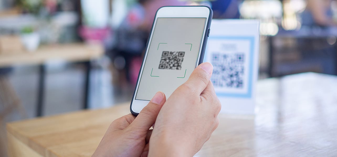 Woman scans an event QR code with her smartphone