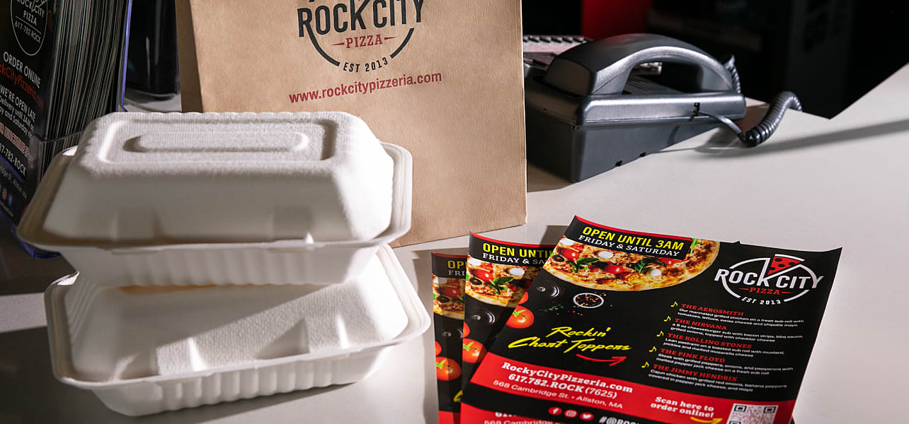 Packaged food and flyers with a QR code for a pizza shop