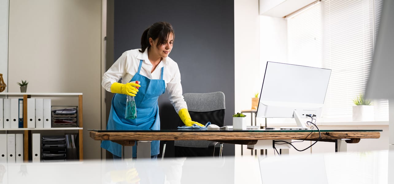 A person cleaning a table in an office