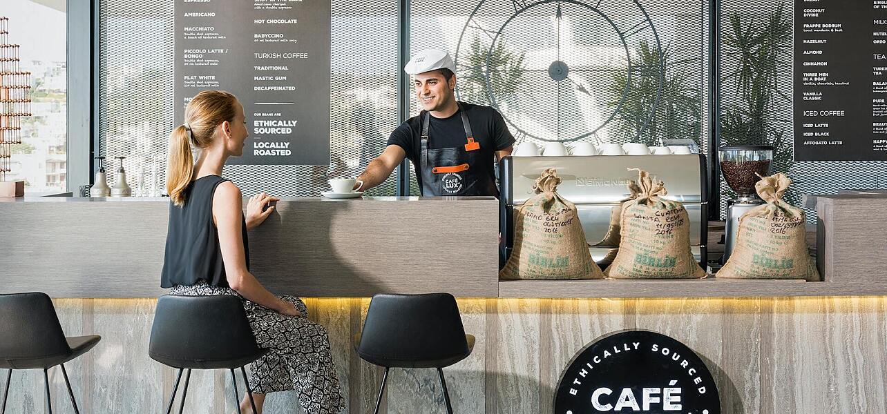 A barista serving a customer at a cafe
