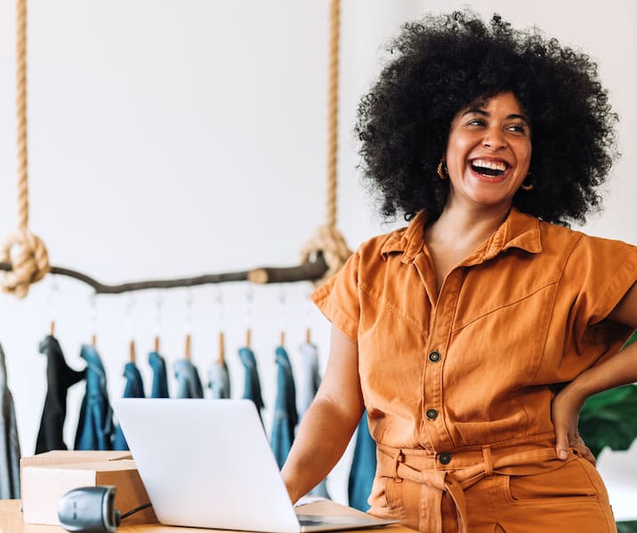 A small business owner smiles in her clothing store