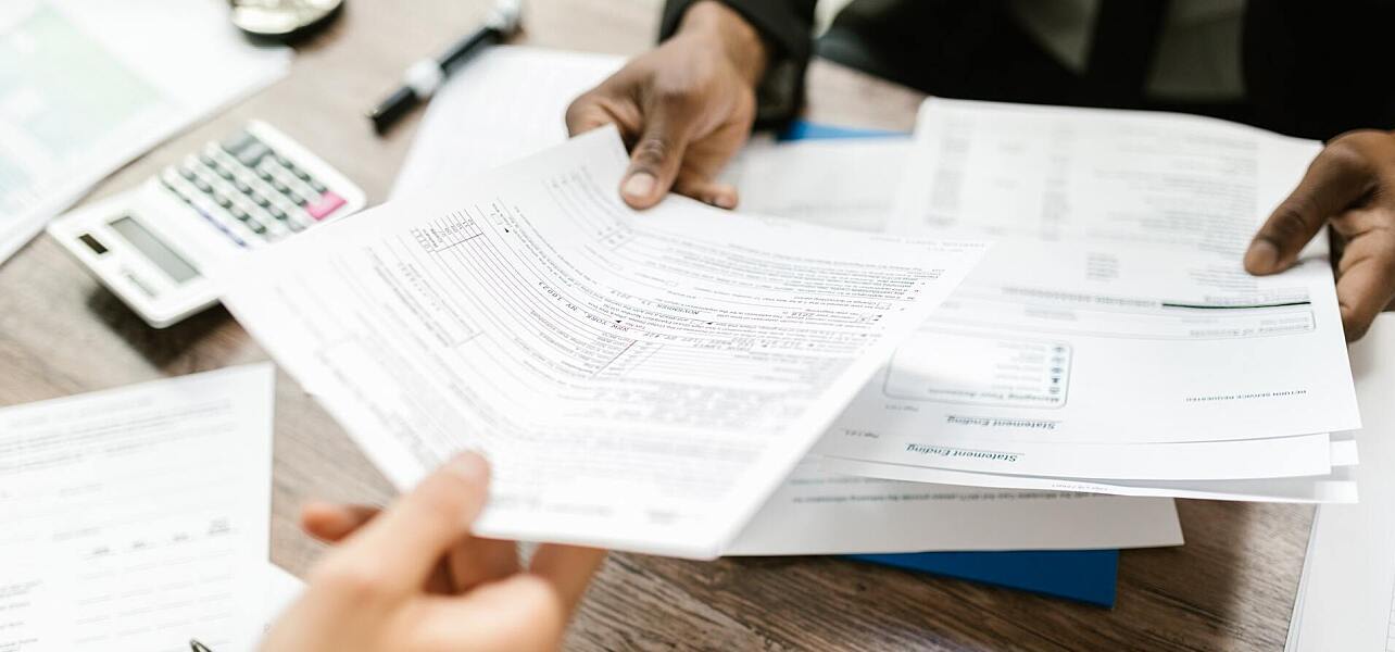 Person passing a tax form to their accountant