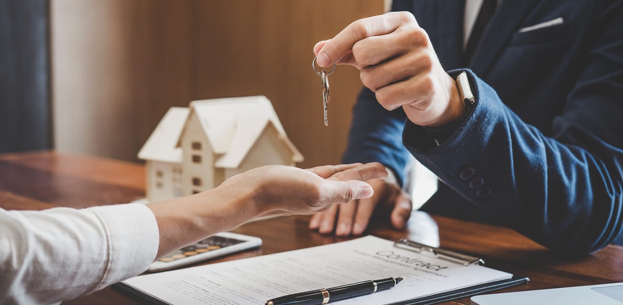 Real estate agent handing house keys over to a new home buyer