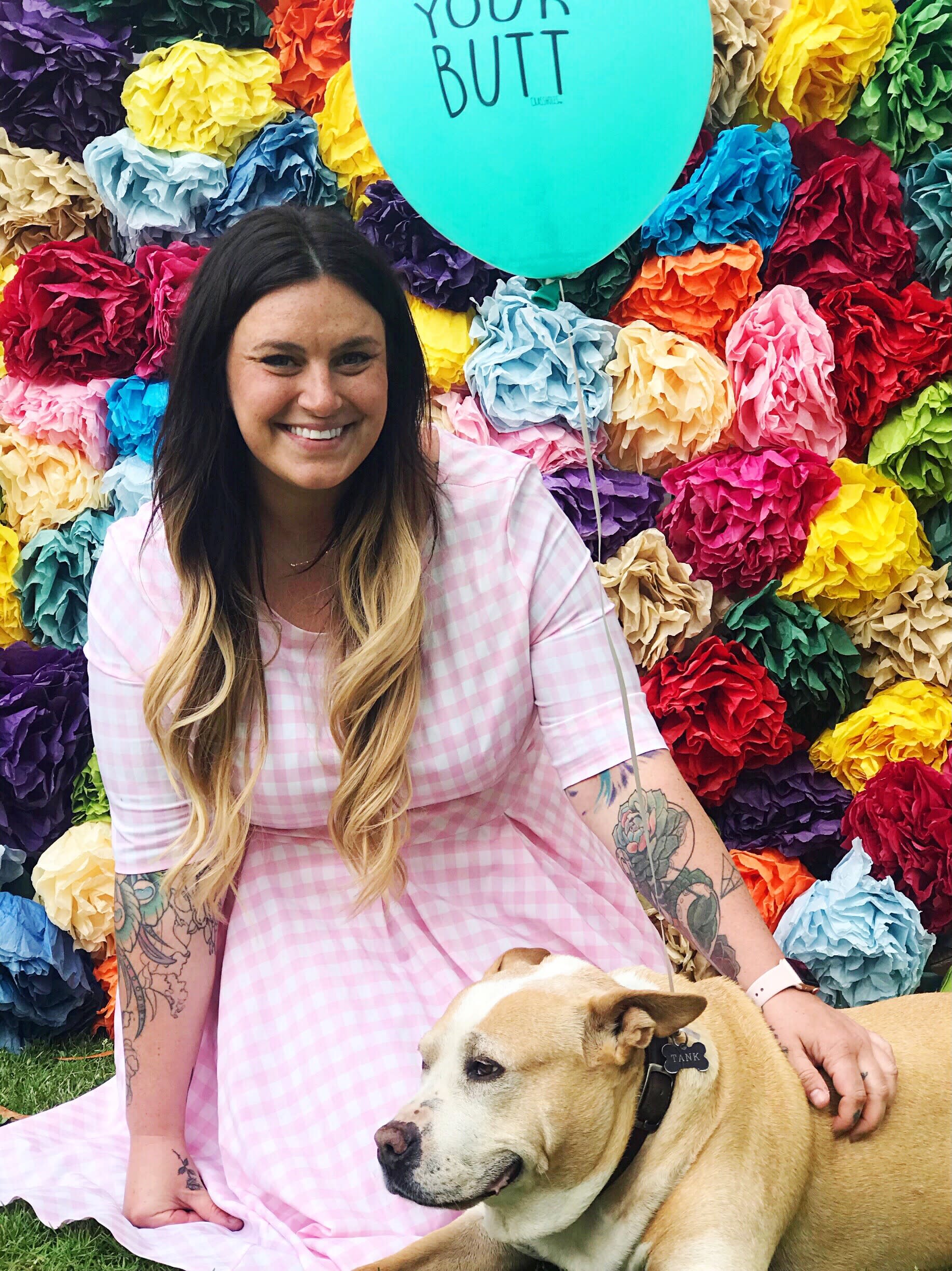 Caitlin Minges with a dog and a background of flowers