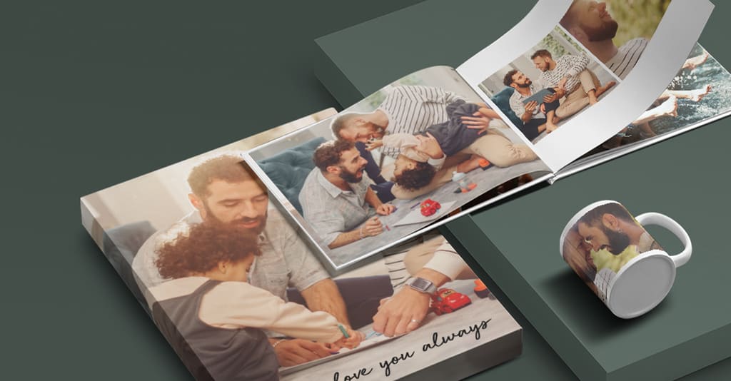 Two photo books featuring images of two dads with their children, next to a mug with a photo of dads printed on it