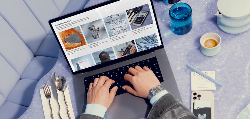 Hands typing on laptop in a cosmic-inspired, purple toned office setting