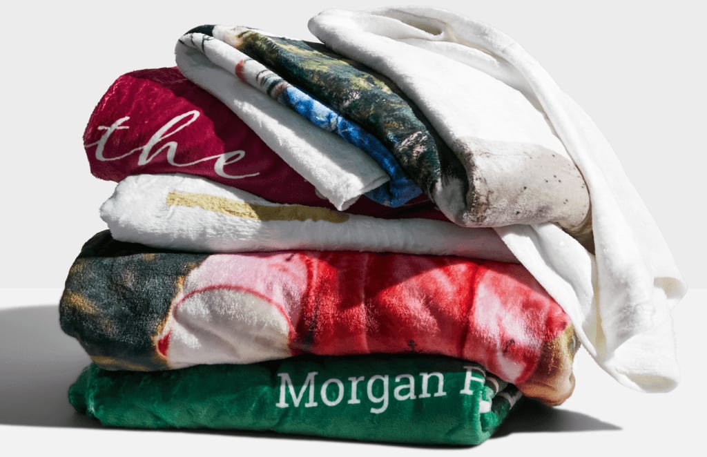 A stack of customized fleece blankets folded.