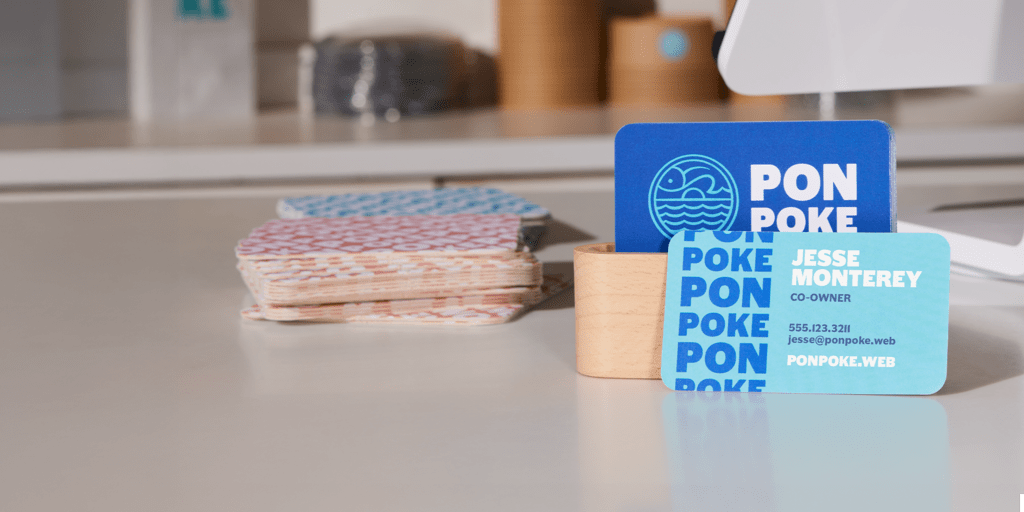 Elegant and original business card design resembling playing cards, displayed on a candle-decorated table in soft, calming tones.