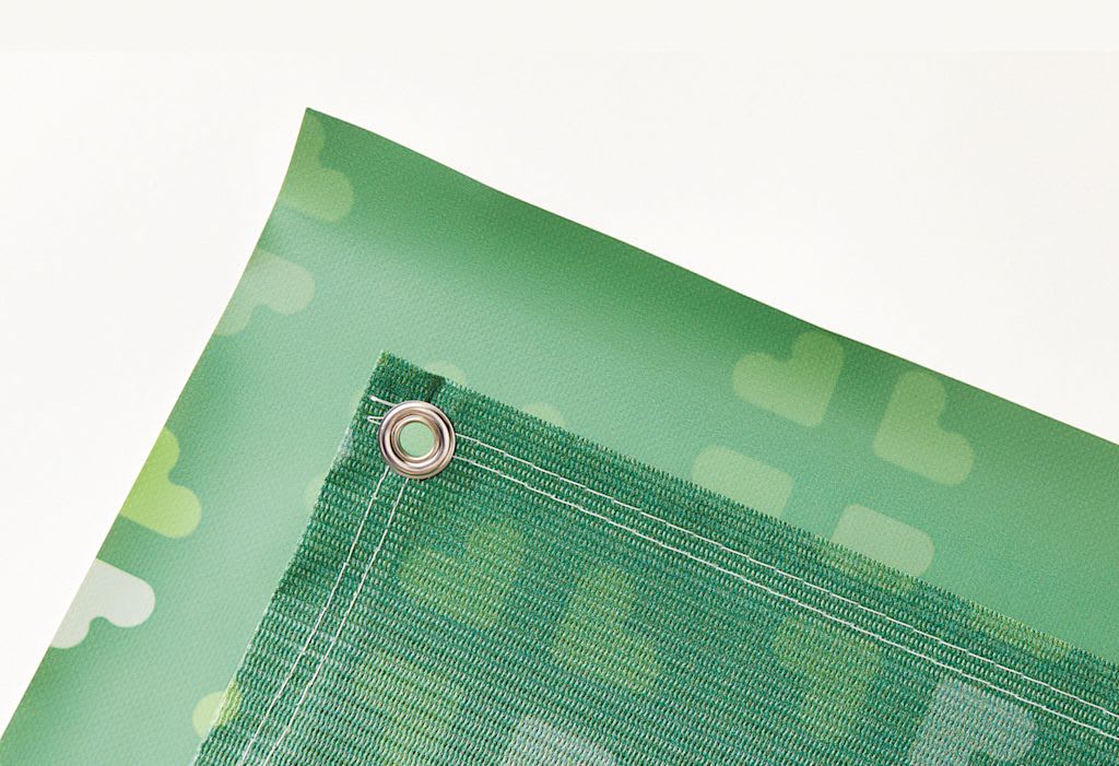 Corner of green mesh banner and its grommet