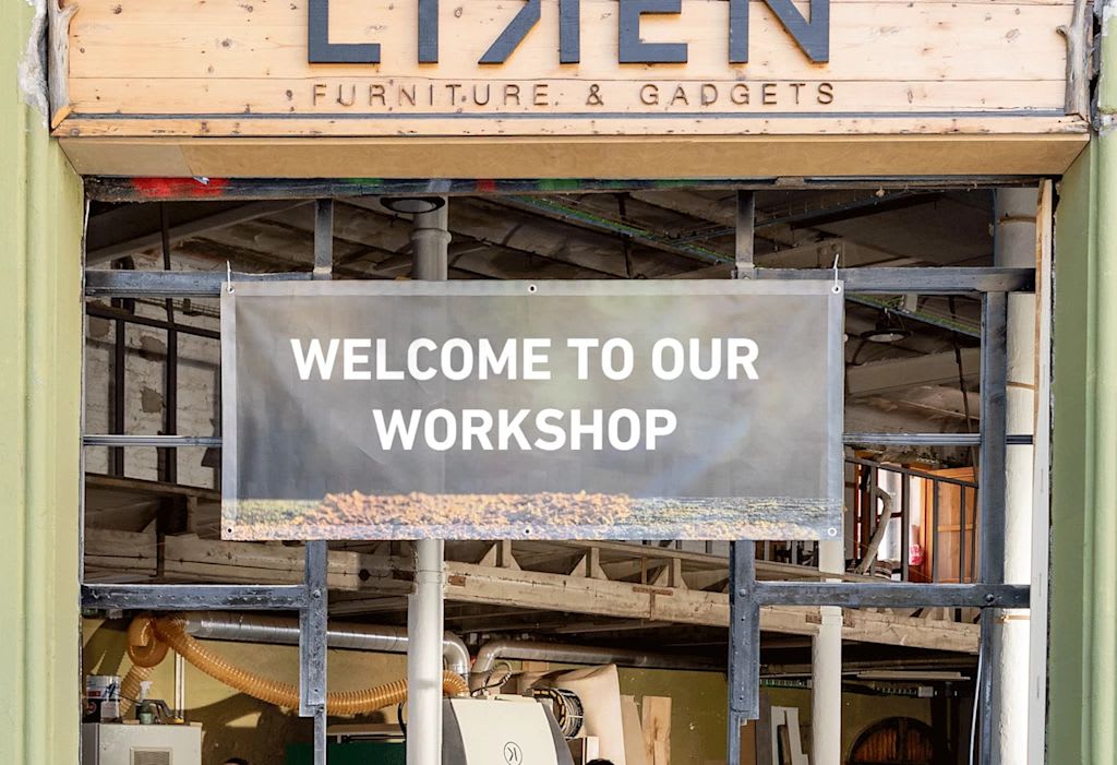 Rectangular mesh banner with text saying “Welcome to our workshop” hung on a frame