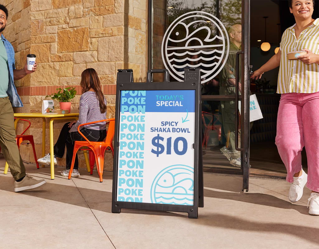 Blue and white A-frame sign advertising poke bowls