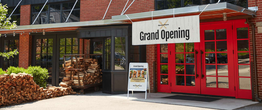 A hanging banner advertising a grand opening types of signs.
