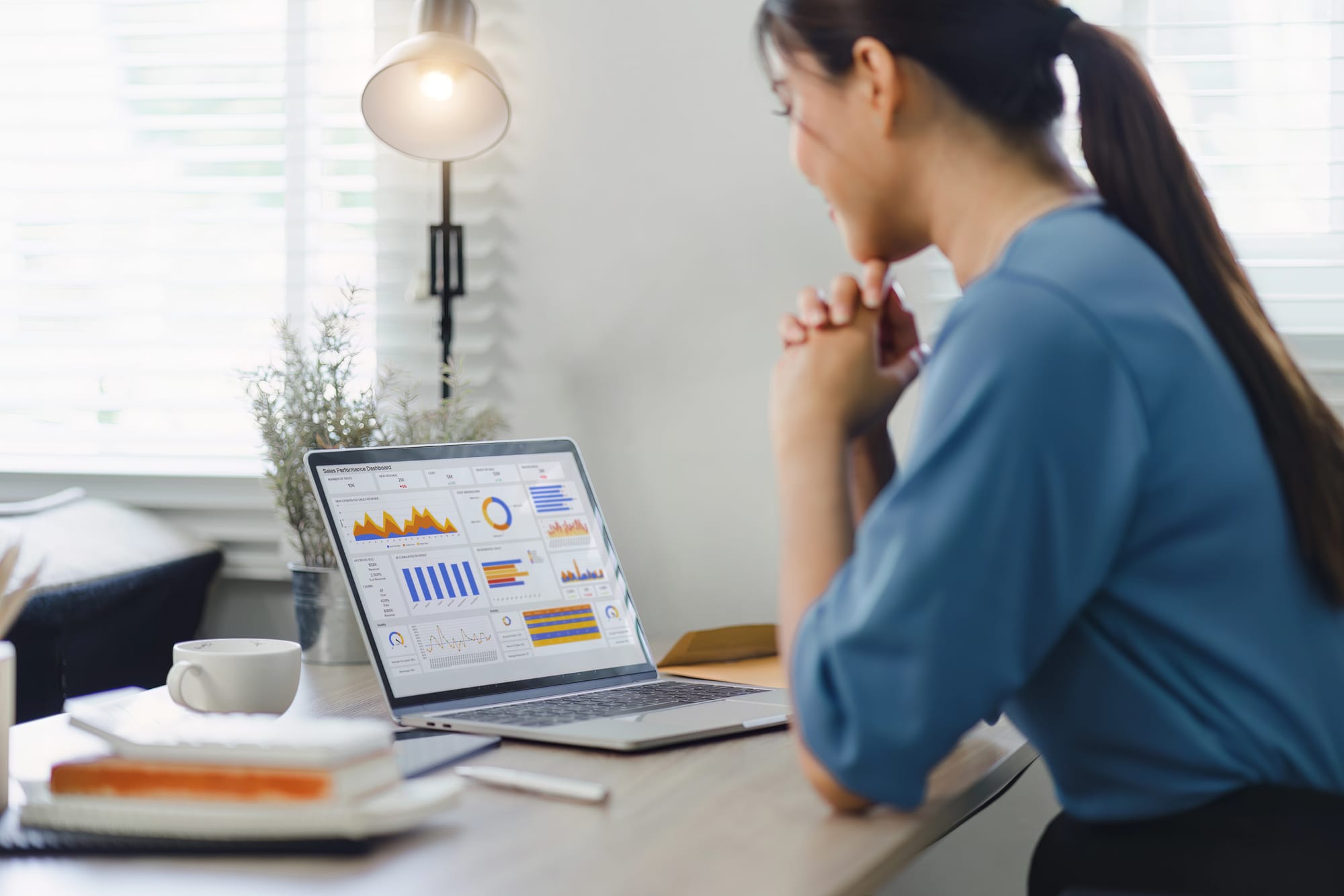 Woman analyzing key metrics on a laptop screen.