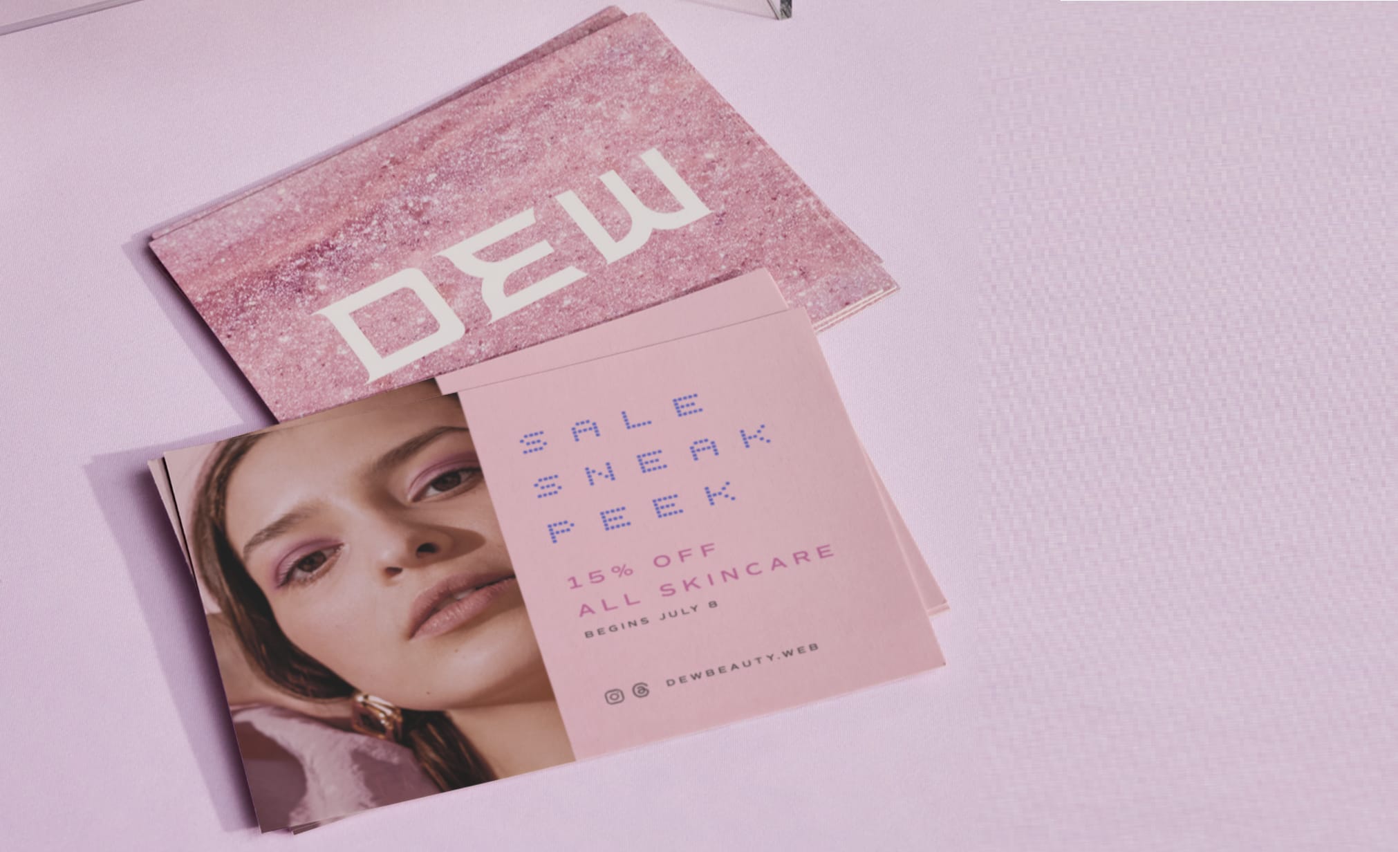 Stack of branded skincare postcards featuring a model, promotional offer, and pink-toned design – example of postcard marketing.