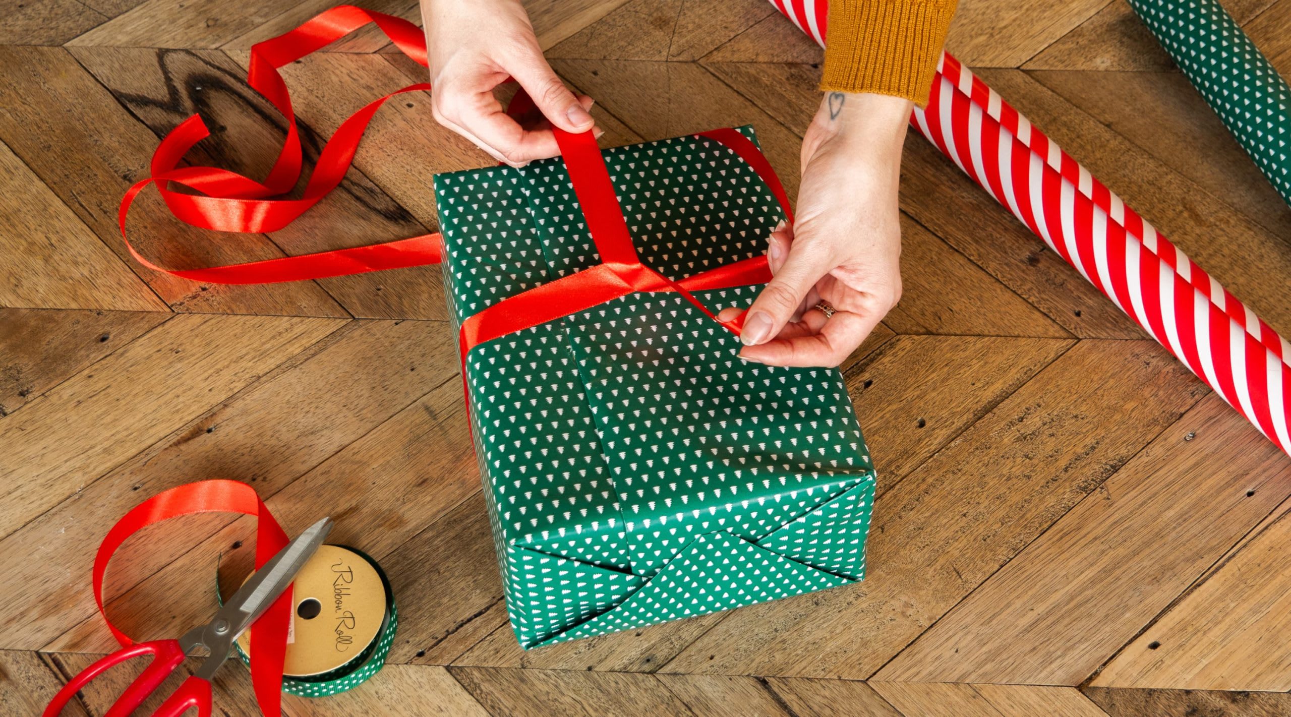Eine Person zeigt, wie man das Geschenkband richtig verknotet