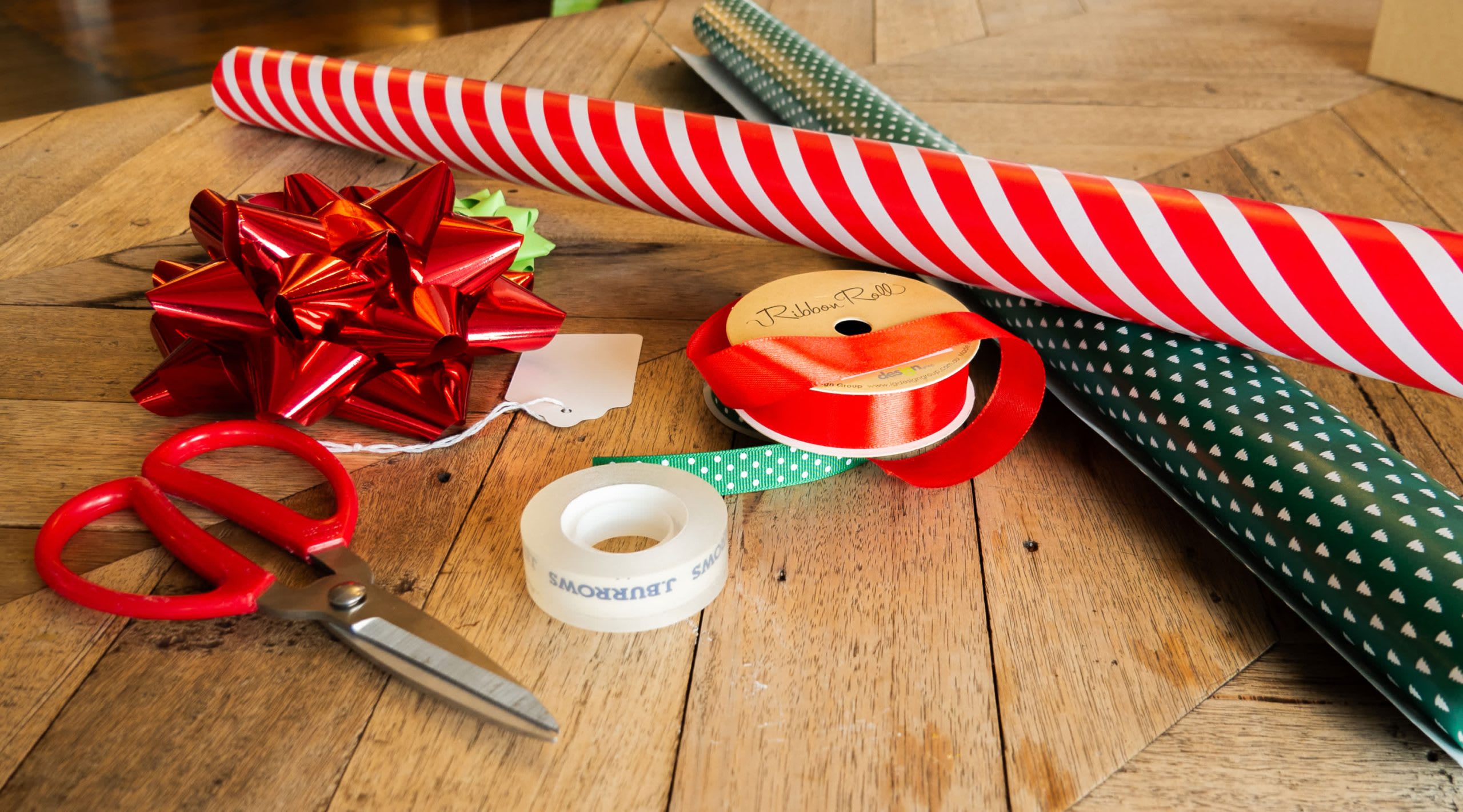 Set mit Geschenkpapier, Band, Klebeband und Schere zum Verpacken von Geschenken